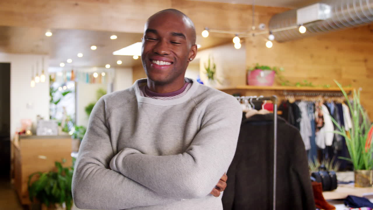 Smiling young black man walks into focus in a clothes shop
