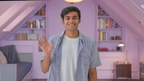 indian boy waving hand and saying hello