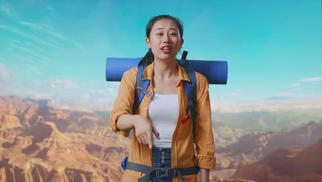asian female hiker with mountaineering backpack making unsatisfied face and shouting someone while traveling at the top of mountain