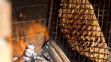 Costilla-De-Cordero-En-Rejilla-Al-Costado-Del-Fuego-De-Leña-Goteando-Grasa-Mientras-Se-Asa-A-La-Parrilla