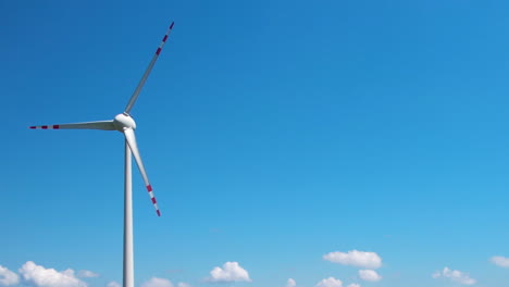 wind vanes swirl against a blue background with a few clouds