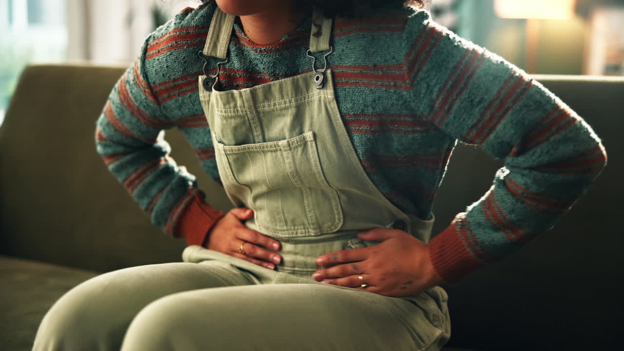 Woman experiencing stomach pain at home