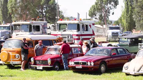 personas admirando coches clásicos en un evento al aire libre