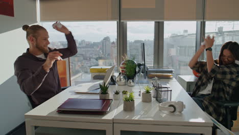 Playful-colleagues-having-fun-at-workplace-close-up.-Happy-couple-throwing-paper