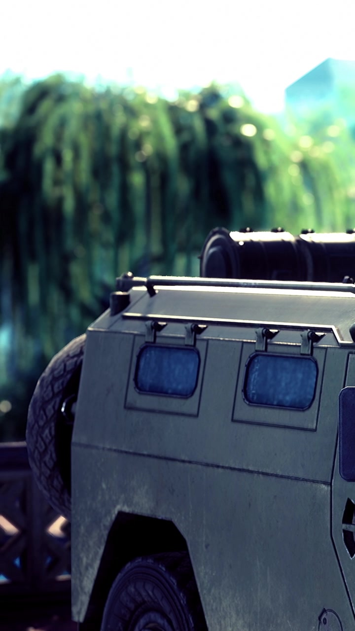 Military vehicle rests against wooden fence with green backdrop