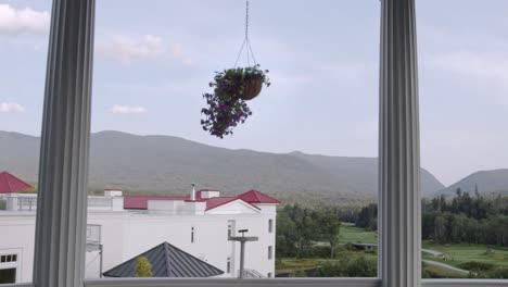 the white mountain range of new hampshire panning shot from the balcony of a hotel, with flower pots hanging in the foreground creating a beautiful frame