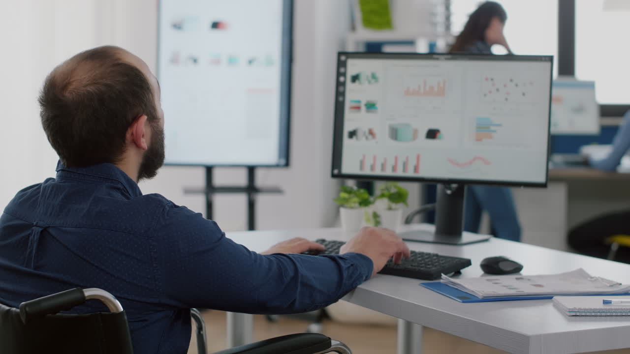 empresario discapacitado escribiendo en la computadora