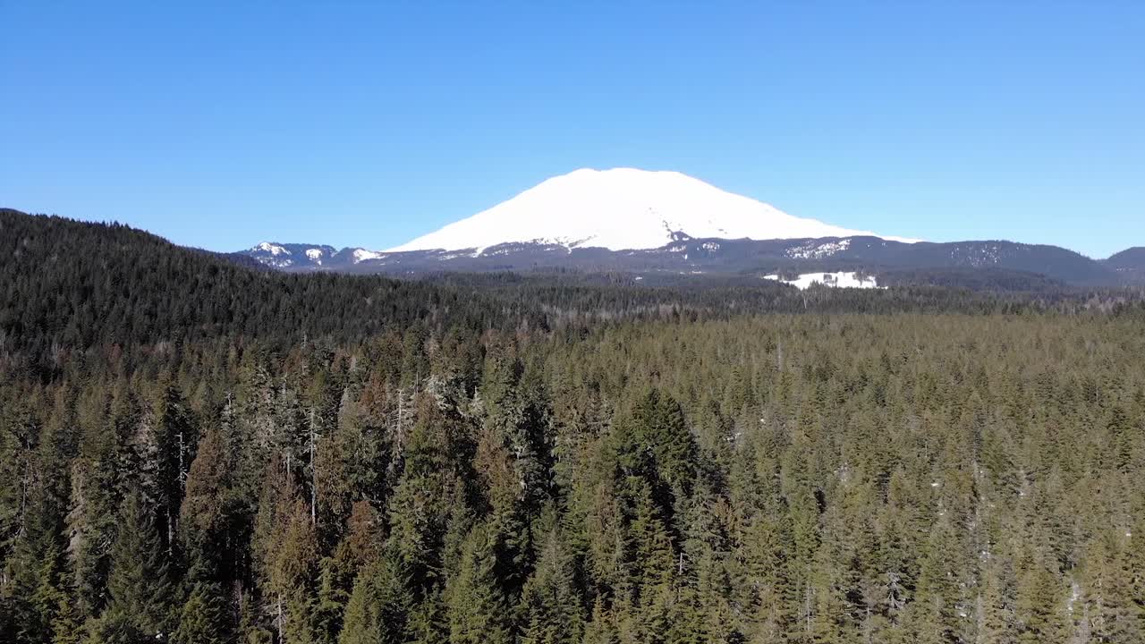 Una ripresa con drone in volo verso il Monte Saint Helens nello stato di Washington, una veduta aerea di una montagna innevata nel Pacifico nord-occidentale.
