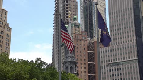 american flag and new york state flag against a background of manhattan skyline