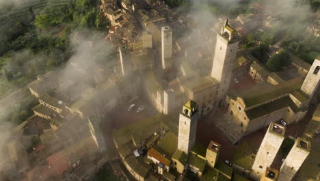 niebla sobre la ciudad de san gimignano en toscana, italia - disparo aéreo de drones