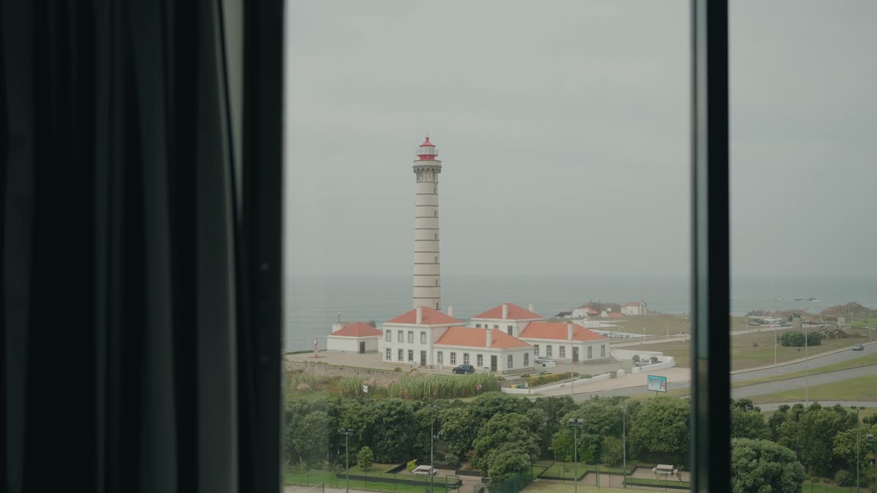 Farol de Leça lighthouse and buildings in Leça da Palmeira, Portugal, seen from a window