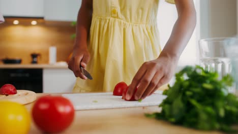 chica cortando tomates en la cocina