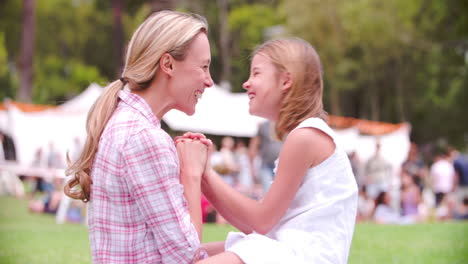 Mother-and-daughter-Eskimo-kissing-at-an-outdoor-event