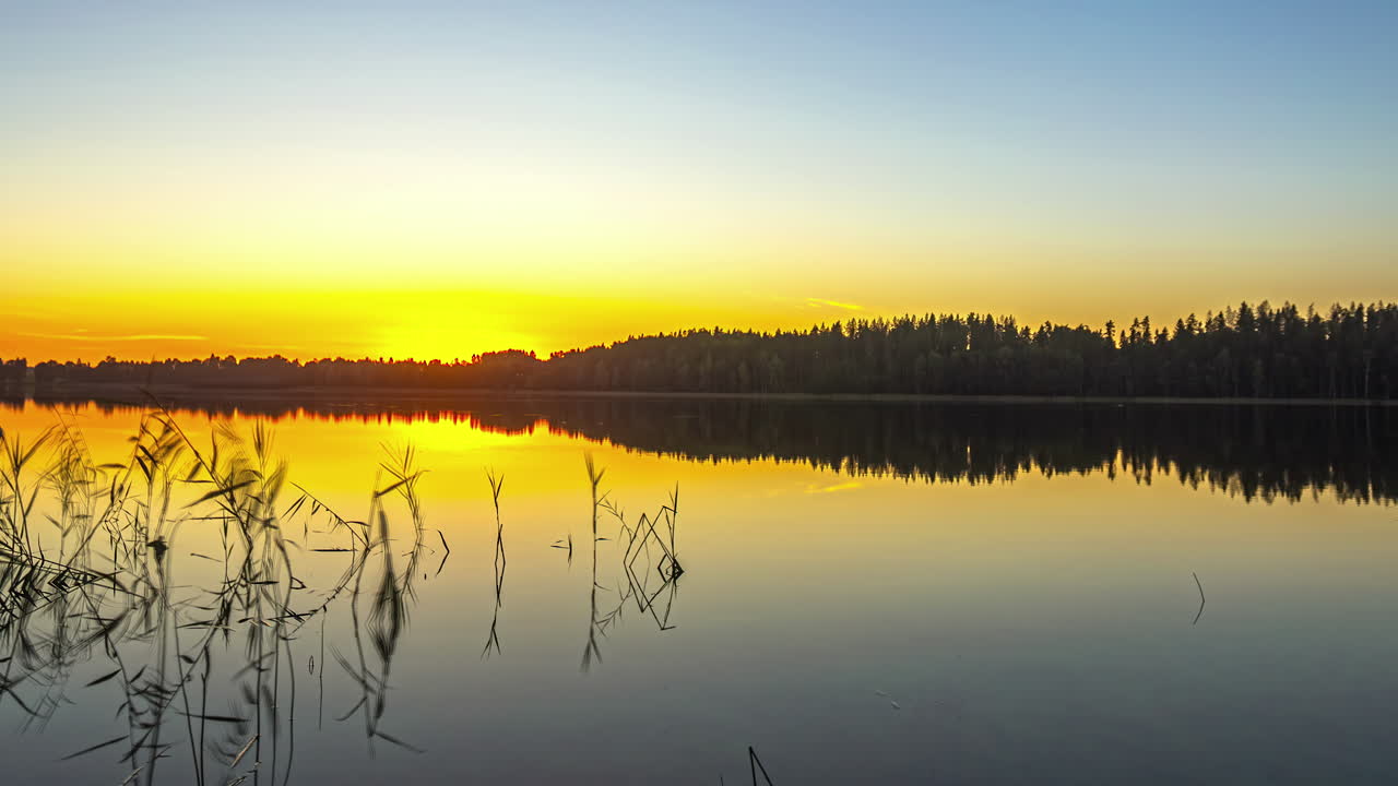 A time-lapse video captures the captivating scenery of a tranquil lake reflecting the sunset
