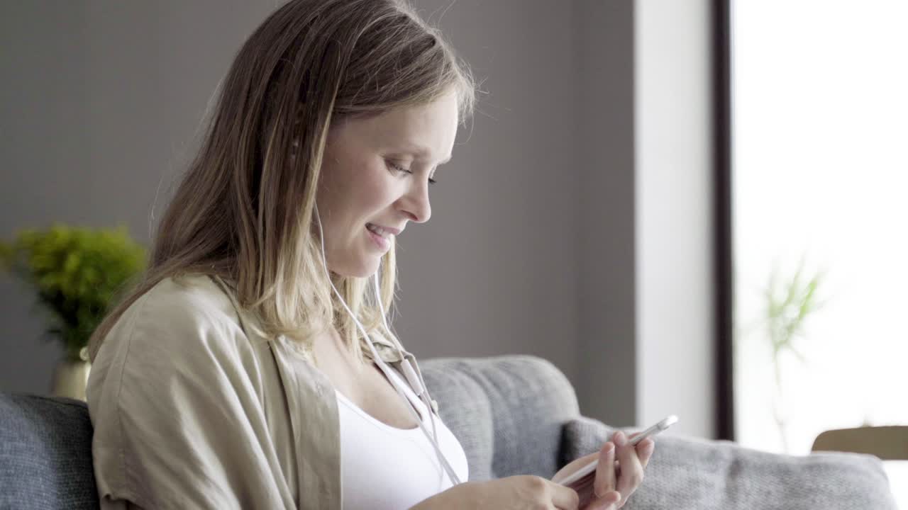 una hermosa mujer joven sonriendo escuchando música con auriculares