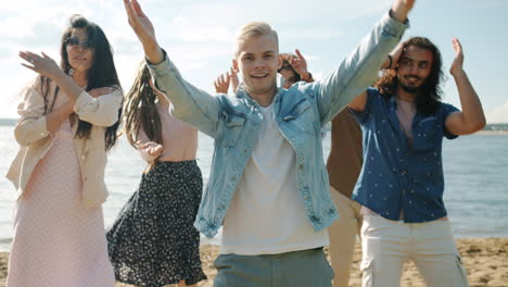 amigos bailando en la playa.