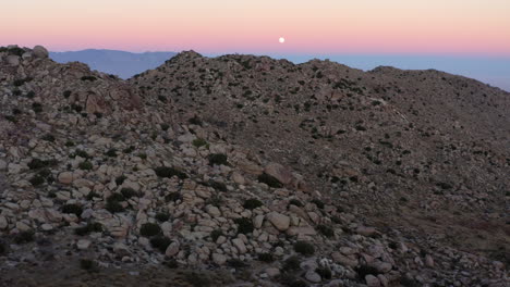 Into-the-Wild,-Rocky-Mountain-in-Desert-Landscape-at-Sunset,-California-State-Park,-Aerial-Backward