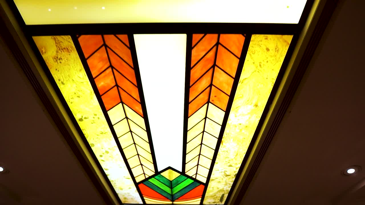 복도 천장에 놓인 상징적인 교회 다색 창문이 앞으로 나아가는 극적인 장면