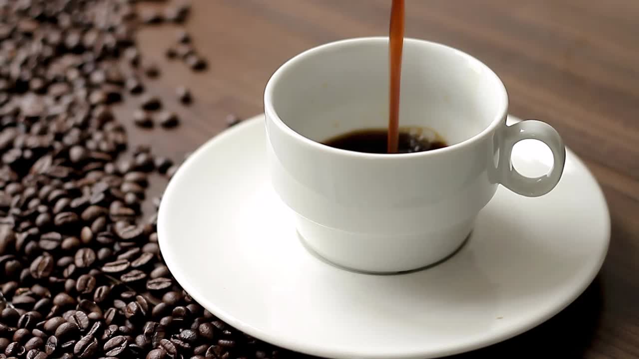 테이블에 원두 커피가 있는 테이블에 뜨거운 블랙 커피 한 잔 스톡 비디오