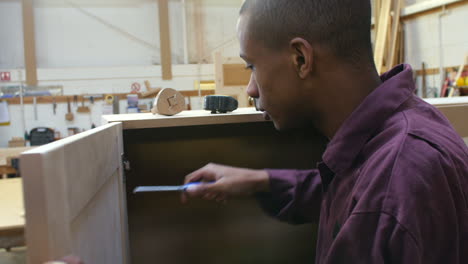 apprentice building furniture in carpentry workshop