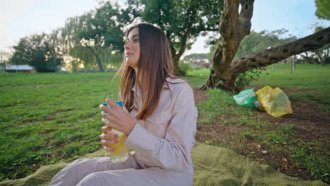 serene woman relaxing picnic in park closeup. girl on blanket drinking water