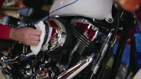 workshop repair man cleans a beautiful and shiny classic motorbike in garage