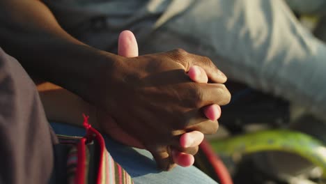 primer plano de una pareja en silla de ruedas tomados de la mano