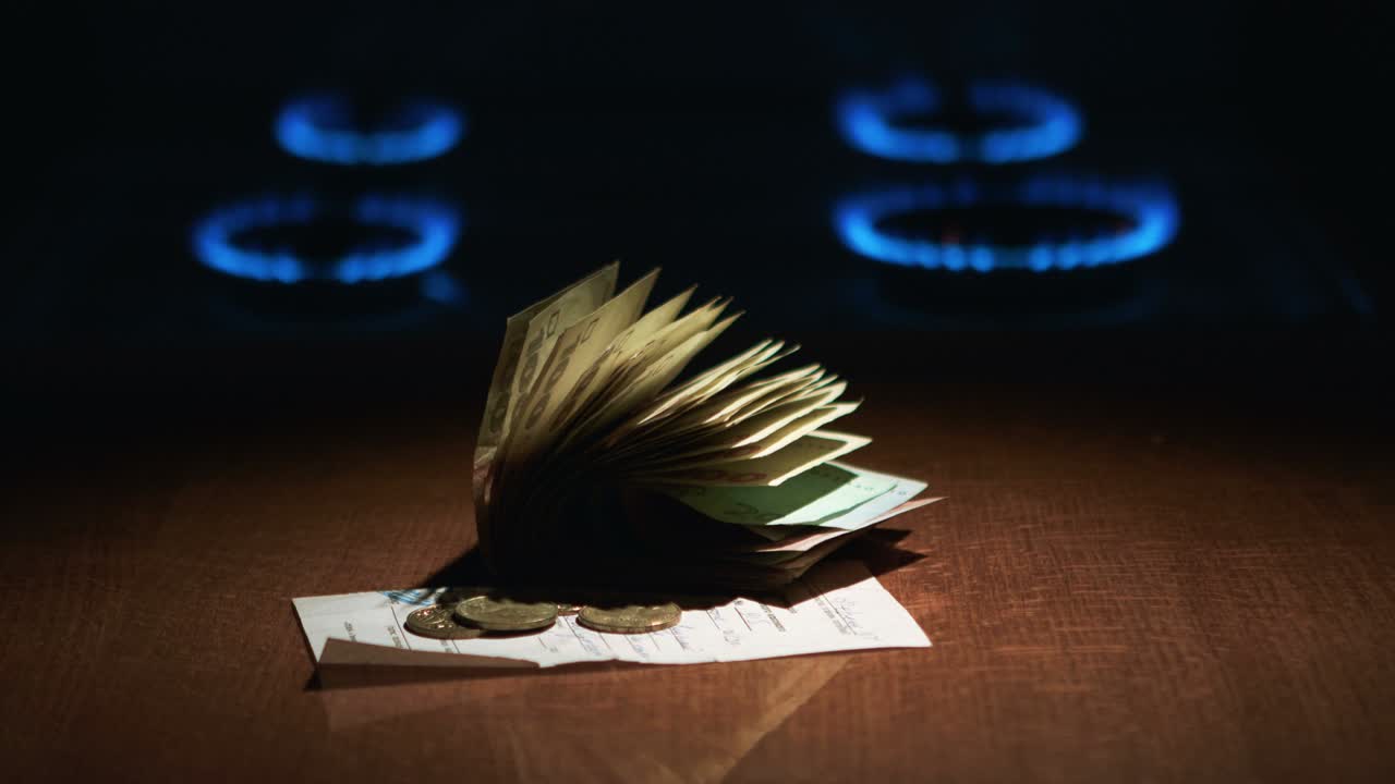 estufa de gas con encendido el gas y recibo de pago de la deuda de los billetes de hryvnia ucraniana de 100 y un centavo cerca. crisis composición de gas