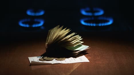 gas stove with lighted the gas and receipt of payment of the debt of ukrainian hryvnia banknotes of 100 and a penny nearby. crisis gas composition