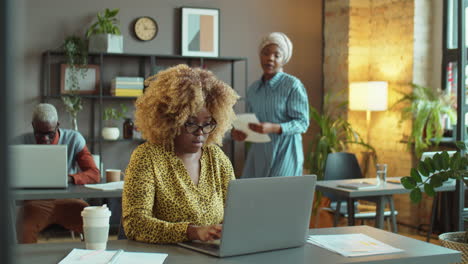 african american businesswomen discussing paper in office