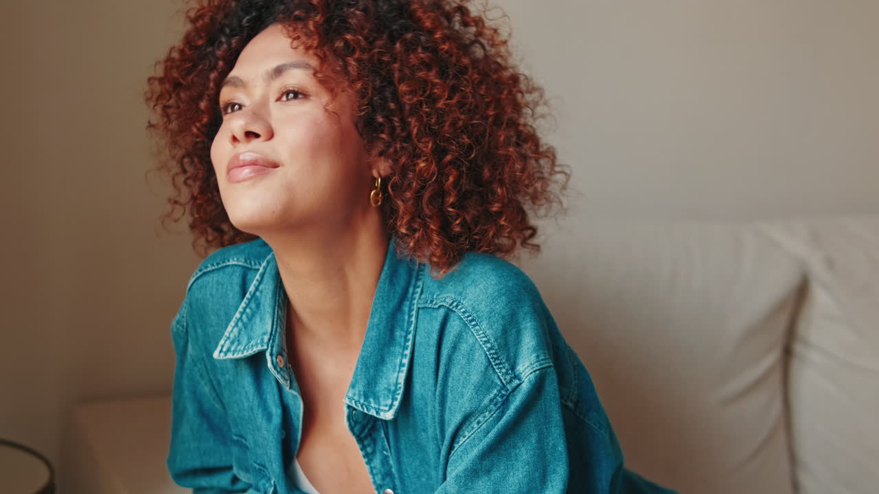 Thoughtful Young Woman with Curly Hair Looking Away Indoors