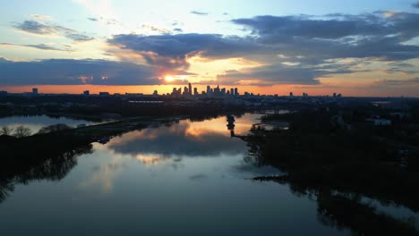 aerial view of sunset view of warsaw's city center skyline and its reflection on the river with beautiful orange hues and clouds