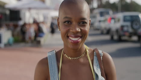 ritratto di una felice donna afroamericana sorridente che gode di uno stile di vita indipendente durante le vacanze estive in una calda e soleggiata strada sul lungomare