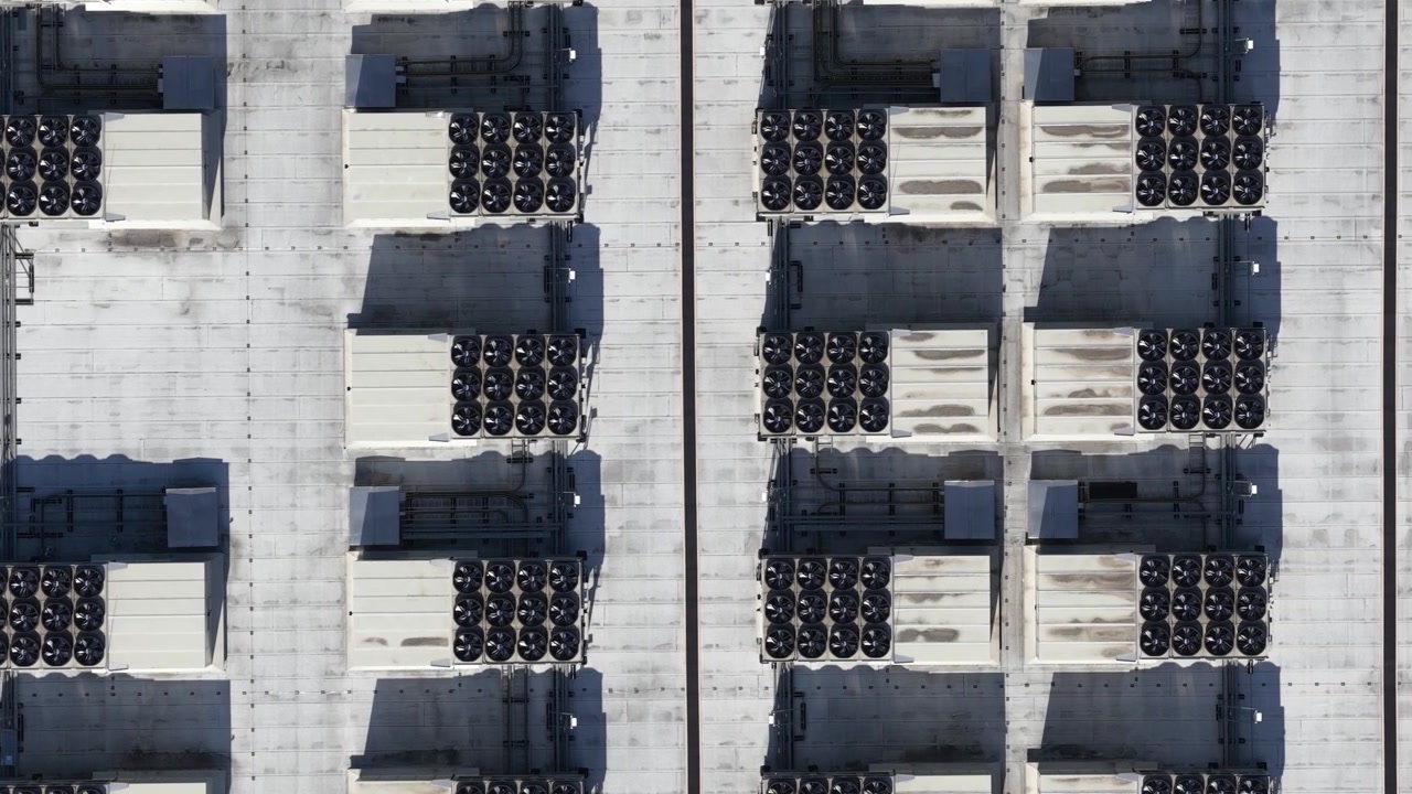 Aerial drone view of data center HVAC systems, showing rooftop cooling units, airflow control and mission critical climate infrastructure.