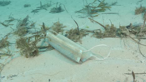 una máscara médica desechada por la pandemia del virus de la corona llega al océano flotando como basura y desechos marinos