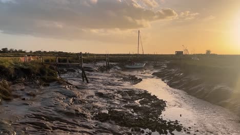 Sailing-boat-docked-in-the-estuary-with-evening-golden-sunset