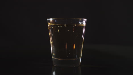 silhouette of a shot glass being filled with whiskey