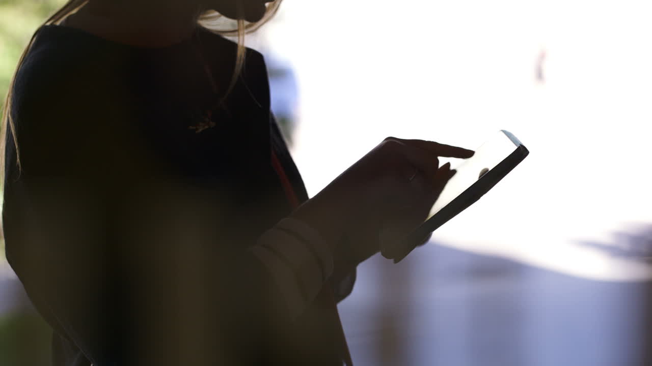 Donna con un touchpad contro una luce intensa