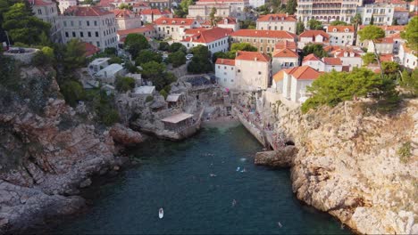 Gente-Nadando,-Saltando-Acantilados-En-La-Playa-Rocosa-De-Sulic-En-La-Bahía-De-Kolorina,-Ciudad-De-Dubrovnik