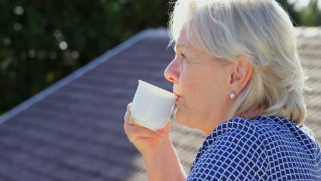 Senior-woman-having-coffee-on-terrace-4k