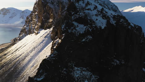 Luftaufnahme,-Die-An-Klippen-An-Der-Felsigen-Küste-Südislands-Vorbeifliegt,-Wintersonnenuntergang