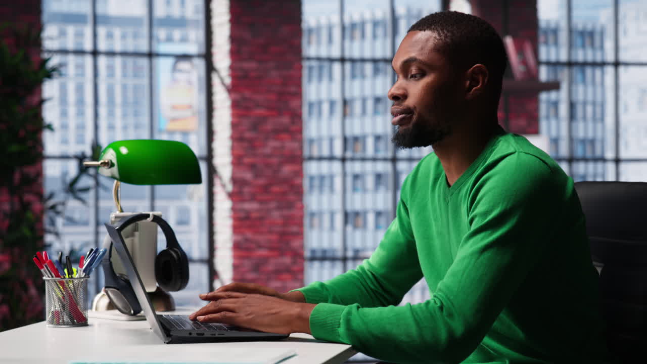 Vertical Video African american focused guy typing on his laptop at home office