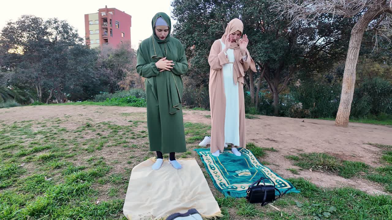 Muslim women praying in a park