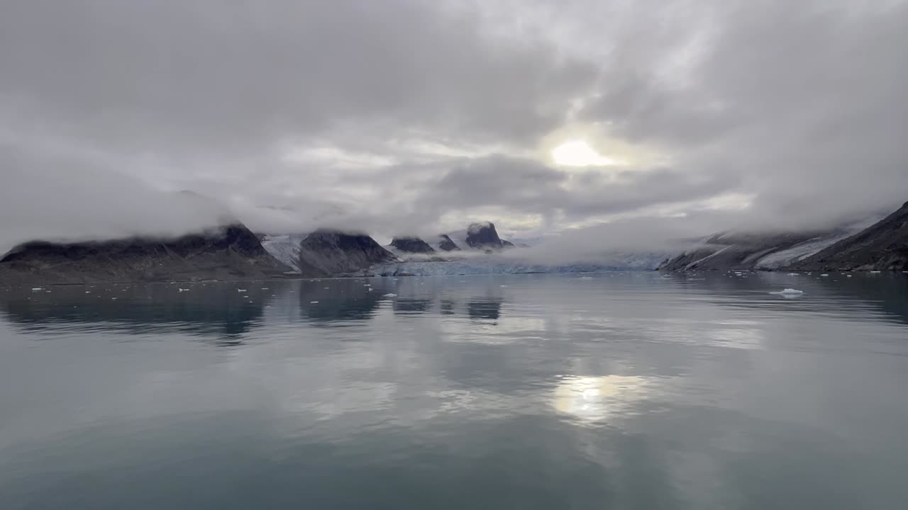 пейзаж в леднике, отражающийся в воде в арктическом море вдоль северного побережья свалбарда во время экспедиционного круиза в облачный день