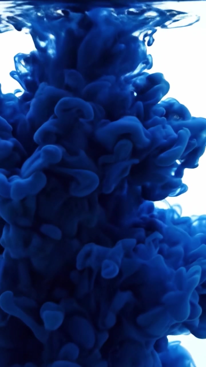Un'Affascinante Esibizione di Inchiostro Blu che Si Mescola Elegantemente nell'Acqua, Mostrando la Bella Trasformazione e il Flusso di Motivi e Texture Colorate in un Ambiente Sereno