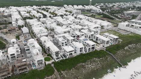 girando hacia la derecha la ciudad de arys playa con muchas casas blancas y edificios con algunos en construcción