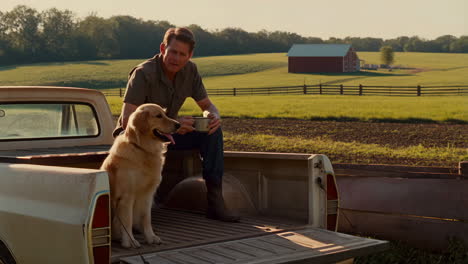 a man and his golden retriever relaxing in the back of a pickup truck on a farm