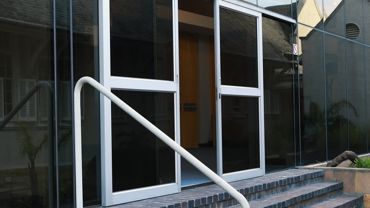 mujer de negocios hablando por teléfono móvil y saliendo del edificio de oficinas 4k