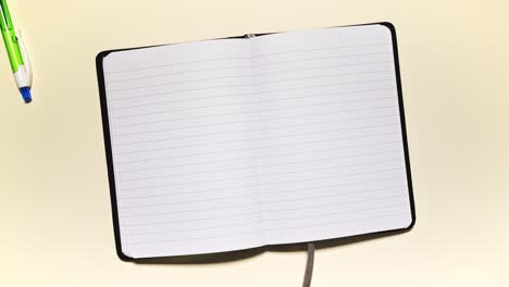 stop motion of stationery framing an open lined notebook, leaving clean copy space on a light background