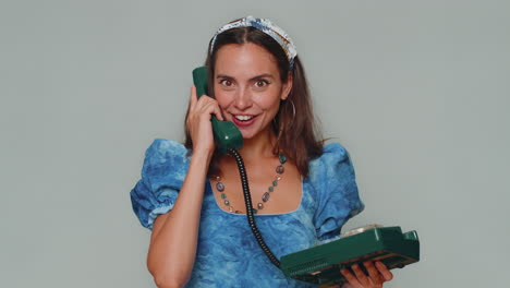 Pretty-woman-in-princess-dress-talking-on-wired-vintage-telephone-of-80s-says-hey-you-call-me-back